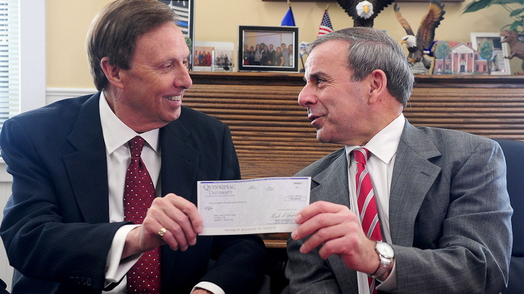 Quinnipiac University President John L. Lahey, left, presents a voluntary payment of $400,000 to North Haven First Selectman Michael J. Freda.