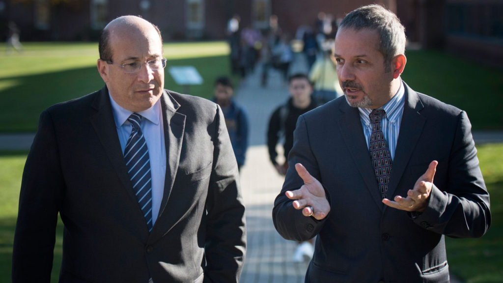 Osman Kilic of North Haven, right, professor of finance and director of the Alternative Investments Institute at Quinnipiac University, chats with Ron Insana, a contributor to Comcast NBCUniversal’s networks CNBC and MSNBC, during Insana’s Nov. 16 visit to Quinnipiac University.  Photo by Autumn Driscoll of Quinnipiac University.