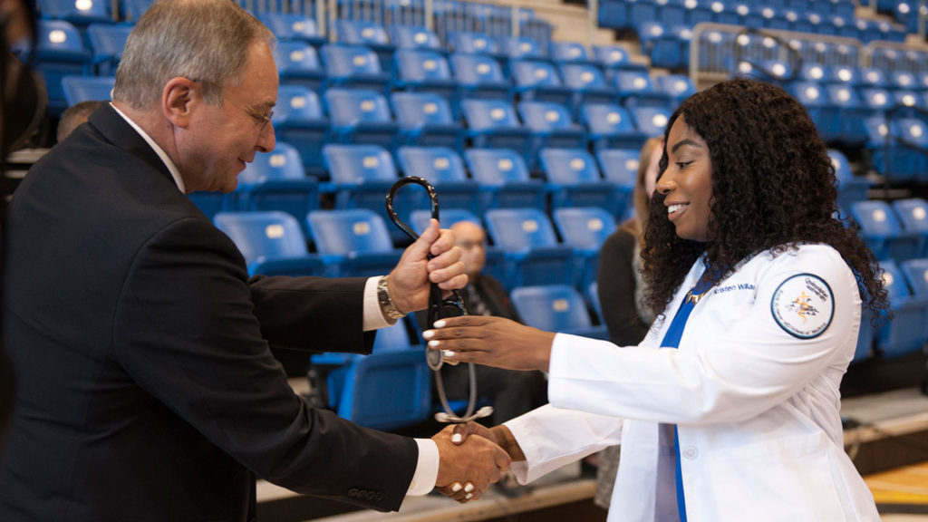 Dr. Bruce Koeppen, dean of the Frank H. Netter MD School of Medicine at Quinnipiac University, presents a stethoscope to first-year medical student Kristen Williams on Aug. 4, at the medical school’s annual White Coat ceremony.
