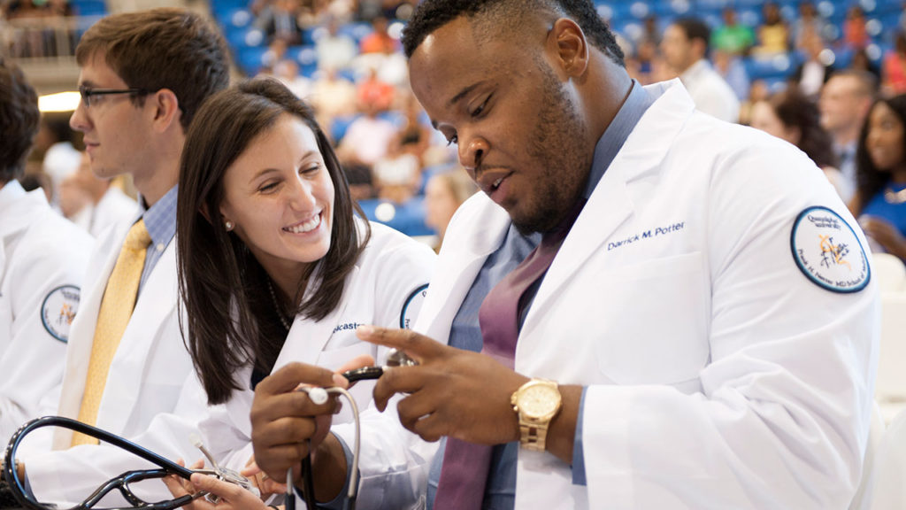 Quinnipiac University first-year medical students, from left, Alexa Policastro, of Saddle River, New Jersey, and Darrick Potter, of New Haven, check out their new stethoscopes during the Frank H. Netter MD School of Medicine’s White Coat Ceremony on Aug. 4 at the TD Bank Sports Center on the university's York Hill Campus.